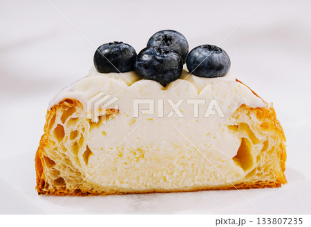 Delicious croissant with cream filling and fresh blueberries on top 133807235