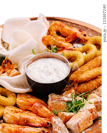 Seafood platter with shrimp, fish and dips served on a wooden tray 133807240