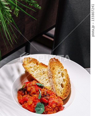 Delicious dish with bread and savory sauce served in a cozy restaurant setting Delicious dish with bread and savory sauce served in a cozy restaurant setting 133807241