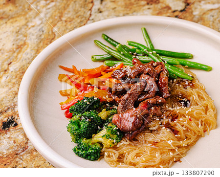 Savoring a colorful plate of stir-fried beef and vegetables with noodles 133807290