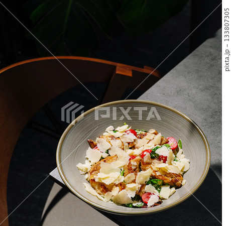 Fresh salad with vegetables and cheese served in a modern restaurant 133807305