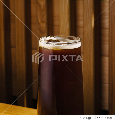 Cold brew coffee served with ice in a cozy cafe setting 133807306