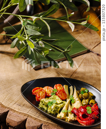 Mediterranean appetizer platter with fresh herbs and vibrant colors in setting 133807320