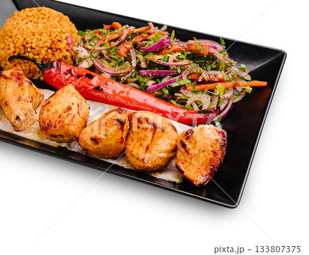 Grilled chicken platter with spicy pepper, salad, and flavorful rice 133807375