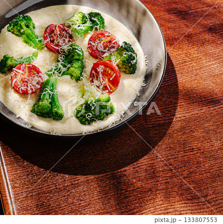 Vegetable casserole with broccoli and tomatoes served in a round dish Vegetable casserole with broccoli and tomatoes served in a round dish 133807553
