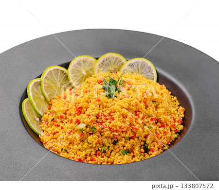 Colorful couscous salad with fresh lime and herbs on a black plate Colorful couscous salad with fresh lime and herbs on a black plate 133807572