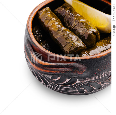 Delicious grape leaves stuffed with rice and herbs served in a traditional bowl Delicious grape leaves stuffed with rice and herbs served in a traditional bowl 133807581