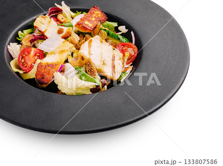 Fresh salad with grilled chicken and nuts served on a dark plate Fresh salad with grilled chicken and nuts served on a dark plate 133807586