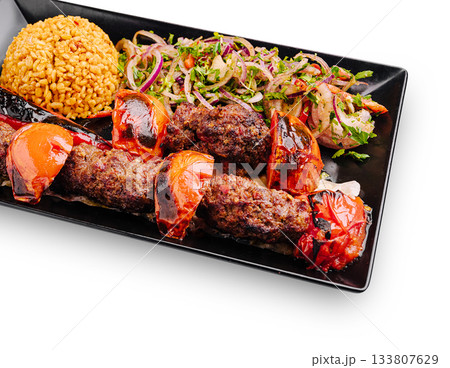 Delicious kebab platter with bulgur and fresh salad served in a restaurant 133807629