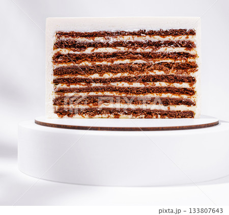 Layered chocolate cake showcased on a simple pedestal Layered chocolate cake showcased on a simple pedestal 133807643