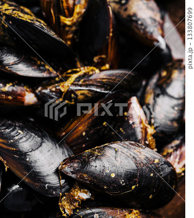Freshly cooked mussels in a rustic bowl with rich golden sauce 133807699