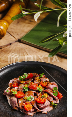 Delicious roast beef with cherry tomatoes served on a rustic table 133807726