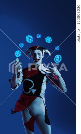 Jester juggling glowing casino icons in vibrant blue lighting 133808030