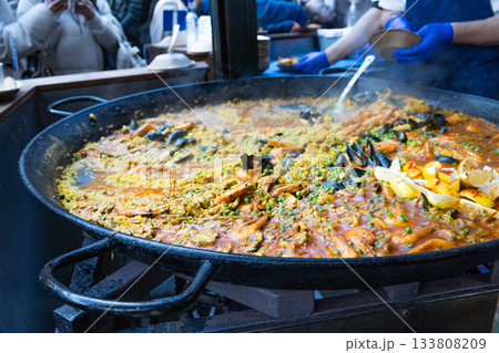 Traditional Spanish Seafood Paella Cooking in Large Pan at Street Market 133808209