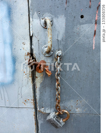 A steel chain hangs from above. Gate opening chain. Gate in the garage. 133808356
