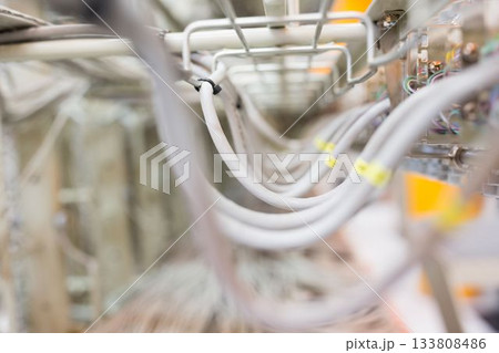 White insulated cables are arching in flat design metal tray with yellow labels and zip ties White insulated cables are arching in flat design metal tray with yellow labels and zip ties 133808486