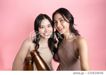 Friendship. Two friends smiling together with drinks in a cheerful moment. Friendship. Two friends smiling together with drinks in a cheerful moment. 133810036