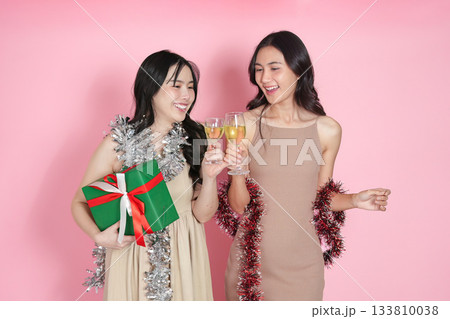 Celebration. Two friends toasting with champagne glasses against a pink background. Celebration. Two friends toasting with champagne glasses against a pink background. 133810038