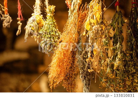 Medicinal plants hang in a village hut for health. Bunches of dried herbs: thyme, calendula, nettle, and chamomile. A folk herbal pharmacy, close-up 133810831