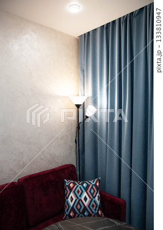 Beautiful modern floor lamp light fixture against turquoise curtain in room, illumination 133810947