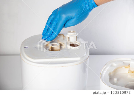 Cleaning the humidifier from scale and rust, microorganisms and unpleasant odors. Cleaning agent. Maintenance of humidifiers, close-up. Copy space for text, industry Cleaning the humidifier from scale and rust, microorganisms and unpleasant odors. Cleaning agent. Maintenance of humidifiers, close-up. Copy space for text, industry 133810972