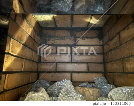 Brickwork of a heating stove. Plate with an oven inside. 133811060