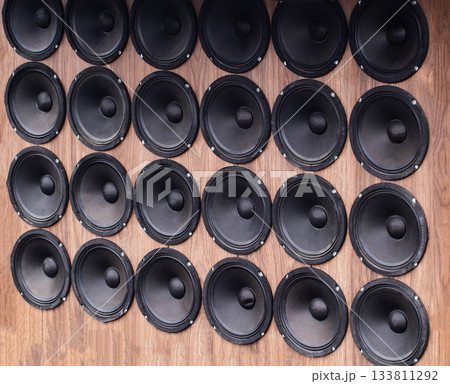 Background Pattern Of Multiple Black Audio Speakers. Woofers Are Arranged Neatly On Wooden Surface. 133811292