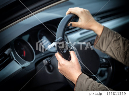 Female Driver Holding Breathalyzer And Steering Wheel. Deciding About Safe Driving After Test. Female Driver Holding Breathalyzer And Steering Wheel. Deciding About Safe Driving After Test. 133811339