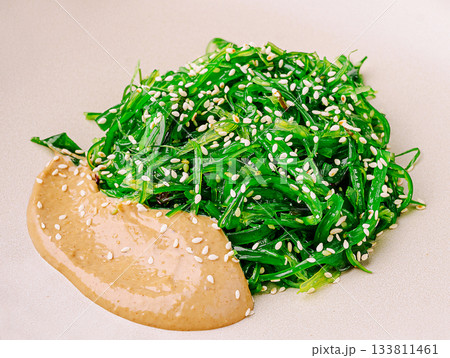 Fresh seaweed salad served with sesame sauce on a neutral background 133811461