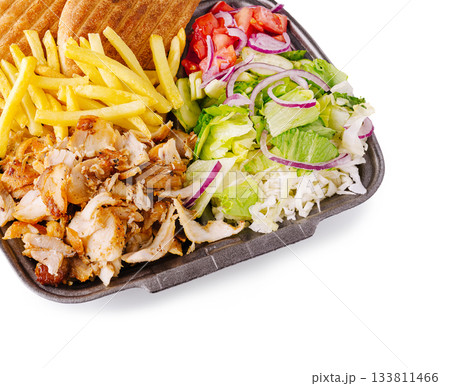 Delicious meal featuring chicken, fries, salad, and pita bread served together 133811466