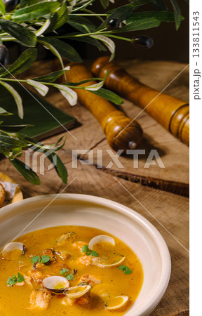 Delicious seafood soup served in a rustic bowl on a wooden table Delicious seafood soup served in a rustic bowl on a wooden table 133811543