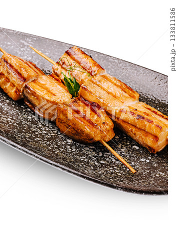 Grilled meat skewers served on a black plate for a delicious meal Grilled meat skewers served on a black plate for a delicious meal 133811586