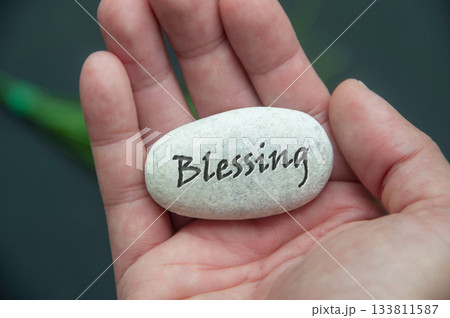Blessing text engraved on a stone hold by hand. Blessing text engraved on a stone hold by hand. 133811587