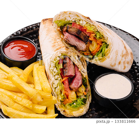 Delicious wrap with beef, fresh vegetables, and fries served on a plate 133811666