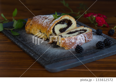 Sliced sweet roll with poppy seeds and blackberries 133812572