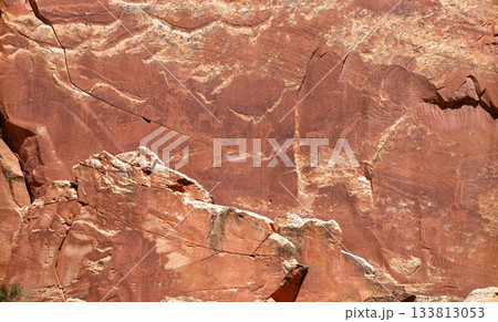 Ancient petroglyphs carved into a red rock sandstone cliff in Capitol Reef National Park. The carvings depict human-like figures and animals from the Fremont Culture Ancient petroglyphs carved into a red rock sandstone cliff in Capitol Reef National Park. The carvings depict human-like figures and animals from the Fremont Culture 133813053