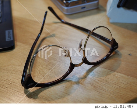 机の上に置かれたメガネ　コピースペース　ビジネスに使える画像　メガネを置いてコーヒーブレイク 133813497