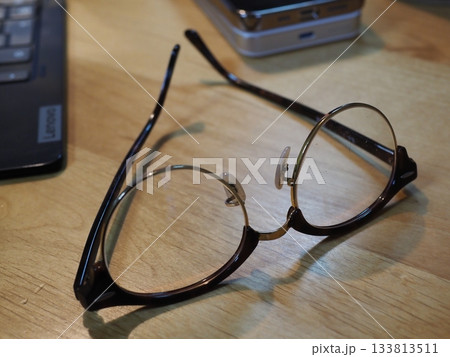 机の上に置かれたメガネ　コピースペース　ビジネスに使える画像　メガネを置いてコーヒーブレイク 133813511