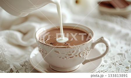 in the delicate porcelain cup, milk is poured into coffee in an elegant and sophisticated manner, creating a luxurious texture with luscious creaminess. in the delicate porcelain cup, milk is poured into coffee in an elegant and sophisticated manner, creating a luxurious texture with luscious creaminess. 133813891
