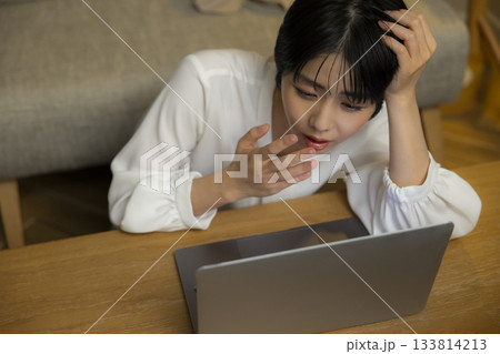 夜に部屋でパソコンを操作する女性 133814213