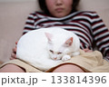 女の子の膝の上で寛ぐ猫 133814396