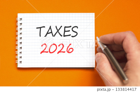 Taxes 2026 new year symbol. Concept words Taxes 2026 on beautiful white note. Beautiful orange paper background. Businessman's hand with pen. Business and taxes 2026 new year concept. Copy space. Taxes 2026 new year symbol. Concept words Taxes 2026 on beautiful white note. Beautiful orange paper background. Businessman's hand with pen. Business and taxes 2026 new year concept. Copy space. 133814417