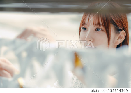 おみくじを結ぶ女性の参拝シーン おみくじを結ぶ女性の参拝シーン 133814549