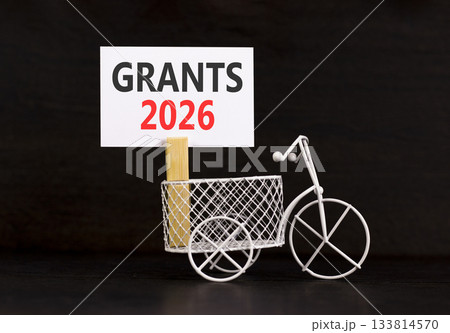Grants 2026 symbol. Concept words Grants 2026 on beautiful white paper on wooden clothespin. Beautiful black background. Beautiful miniature bicycle. Business and grants 2026 concept. Copy space. Grants 2026 symbol. Concept words Grants 2026 on beautiful white paper on wooden clothespin. Beautiful black background. Beautiful miniature bicycle. Business and grants 2026 concept. Copy space. 133814570