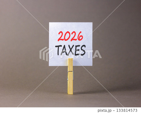 2026 taxes new year symbol. Concept words 2026 taxes on beautiful white paper on wooden clothespin. Beautiful grey background. Business and 2026 taxes new year concept. Copy space. 2026 taxes new year symbol. Concept words 2026 taxes on beautiful white paper on wooden clothespin. Beautiful grey background. Business and 2026 taxes new year concept. Copy space. 133814573