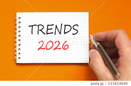 Trends 2026 new year symbol. Concept words Trends 2026 on beautiful white note. Beautiful orange paper background. Businessman's hand with pen. Business and Trends 2026 new year concept. Copy space. Trends 2026 new year symbol. Concept words Trends 2026 on beautiful white note. Beautiful orange paper background. Businessman's hand with pen. Business and Trends 2026 new year concept. Copy space. 133814640