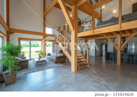 Spacious living area features wood beams, large windows, and a cozy atmosphere, blending modern design with nature views Spacious living area features wood beams, large windows, and a cozy atmosphere, blending modern design with nature views 133814826