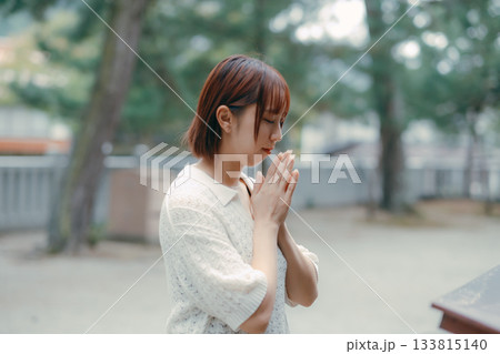 神社で参拝する女性 133815140