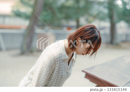神社で参拝する女性 133815149