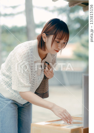 神社で参拝する女性 133815156